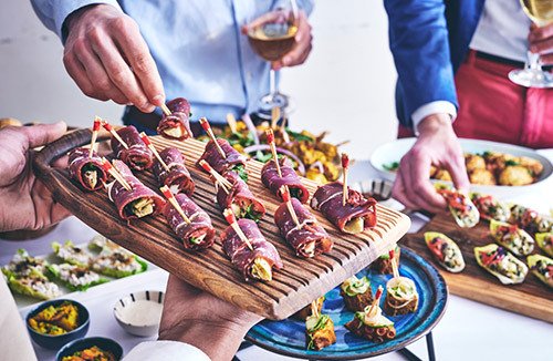traiteur cocktail dînatoire - maître d'hôtel servant des pièces cocktails à des invités pendant une réception professionnelle